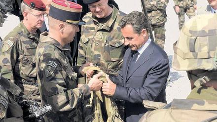 Anschauungsunterricht. Frankreichs Präsident Nicolas Sarkozy lässt sich bei seinem Kurzbesuch auf einem Stützpunkt in der Nähe der afghanischen Hauptstadt Kabul eine kugelsichere Weste zeigen. Foto: Philippe Wojazer/AFP