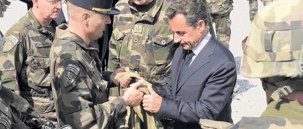 Anschauungsunterricht. Frankreichs Präsident Nicolas Sarkozy lässt sich bei seinem Kurzbesuch auf einem Stützpunkt in der Nähe der afghanischen Hauptstadt Kabul eine kugelsichere Weste zeigen. Foto: Philippe Wojazer/AFP