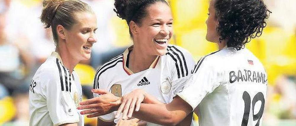 Im Mittelpunkt. Celia Okoyino da Mbabi, hier mit Simone Laudehr (links) und Fatmire Bajramaj (rechts) schoss in drei WM-Testspielen drei Tore. Foto: dpa