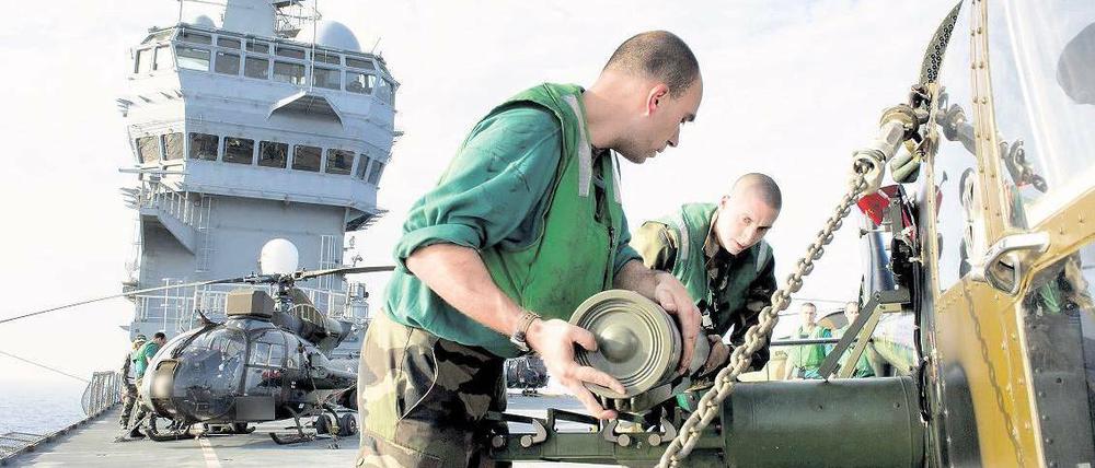 Nachschubprobleme. Diese französischen Soldaten montieren Raketen an einem Hubschrauber vor der libyschen Küste. Knappe und fehlende Ausstattung machen es den Militärs schwer, den politischen Ehrgeiz ihrer Regierungen zu erfüllen. 
