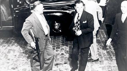 New York 1944. Mafia-Boss Louis Buchalter (Mitte) wird zum Gericht gebracht. Er stirbt auf dem Elektrischen Stuhl. 