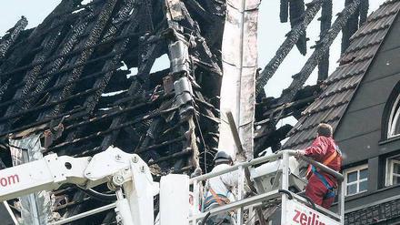 Ein Bild der Zerstörung. Nach dem Dachstuhlbrand in dem denkmalgeschützen Bau in Charlottenburg am Freitag gingen die Aufräumarbeiten am Tag danach weiter.