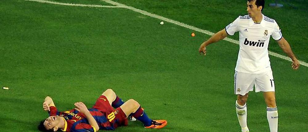 Klassisch: Barcas Messi am Boden, und keiner will's gewesen sein. Auch nicht der Madrider Arbeloa.