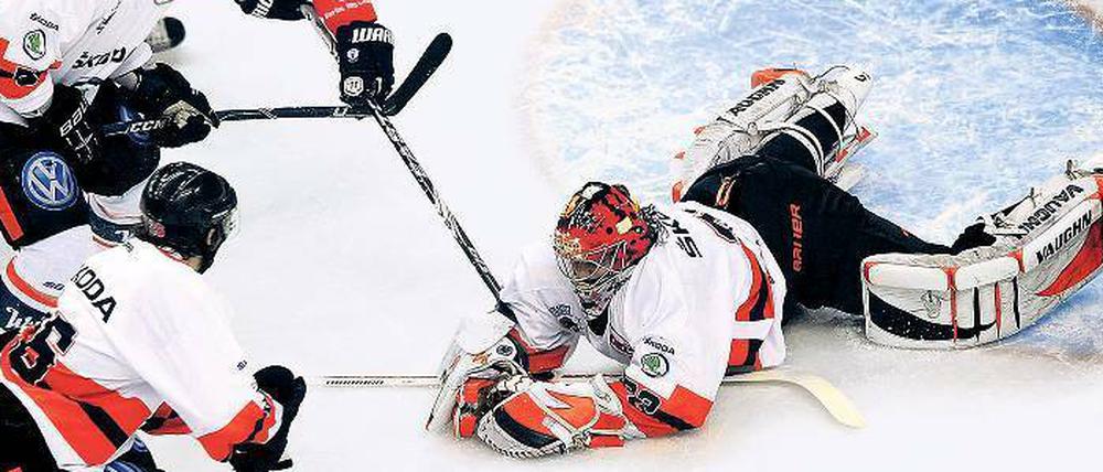 Die Grizzlys sind am Boden. Wolfsburgs Torwart Jochen Reimer (rechts) hält zwar in dieser Szene den Puck vor dem Eisbären-Stürmer Andre Rankel (hinten). Aber das Spiel gewannen die Berliner und stehen damit kurz vor dem Titelgewinn. 