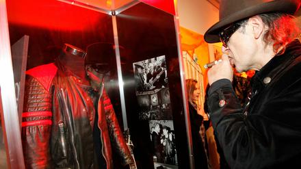 Udo Lindenberg betrachtet eine ausgestellte Lederjacke, die er einst Erich Honecker schenkte.