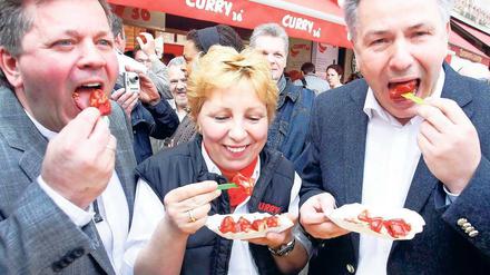 Curry-36-Inhaber Lutz Michael Stenschke, Chefin Vera Stenschke und Klaus Wowereit lassen sich eine Currywurst schmecken.