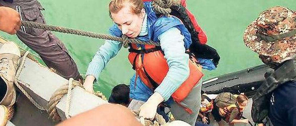 Mit einem Seil werden Urlauber auf den Flugzeugträger „Chakri Naruebet“ hochgezogen. 