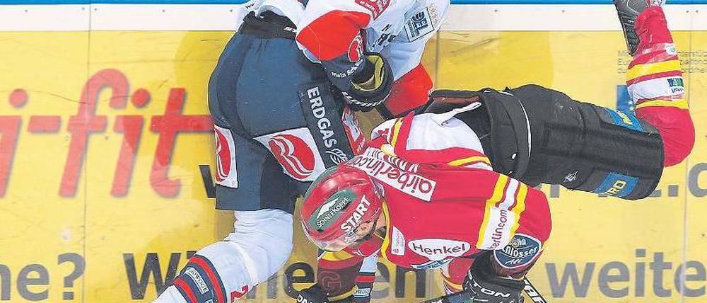 Spiel auf dem Kopf. Berlins Florian Busch (l.) übertrumpft Düsseldorfs Evan Kaufmann. Doch in der Verlängerung ermöglicht Buschs Fehler Kaufmann den Siegtreffer. Foto: dpa