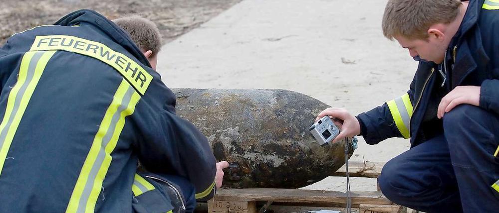 Feuerwehrmänner vor der entschärften 250-Kilo-Bombe.