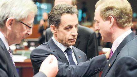 Keine Schonfrist für den neuen Premier. Luxemburgs Premierminister Jean-Claude Juncker (links) und Frankreichs Staatschef Nicolas Sarkozy (Mitte) sprechen mit dem frisch gewählten irischen Regierungschef Enda Kenny.