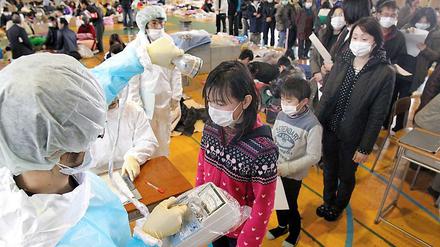 Geordnetes Anstehen: Kinder in Fukushima werden Mit Strahlenmessgeräten untersucht.