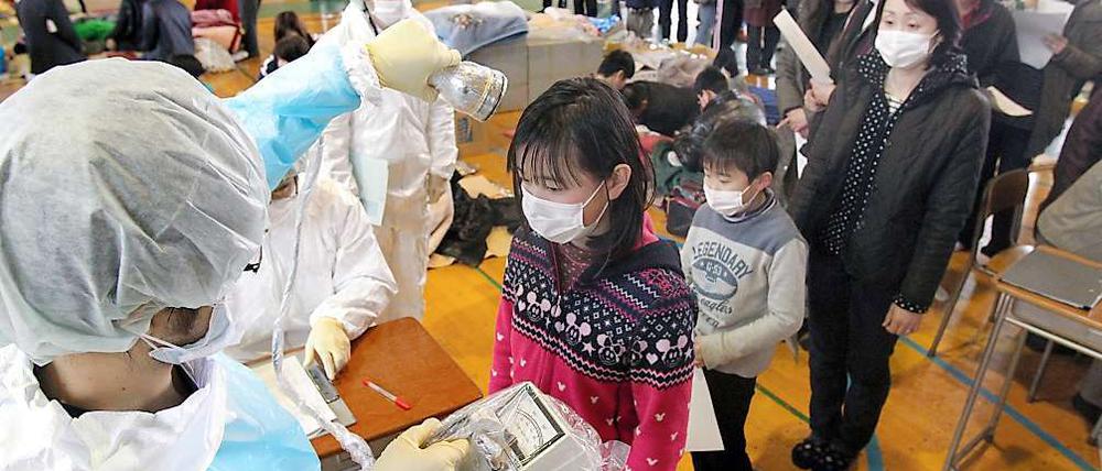Geordnetes Anstehen: Kinder in Fukushima werden Mit Strahlenmessgeräten untersucht.