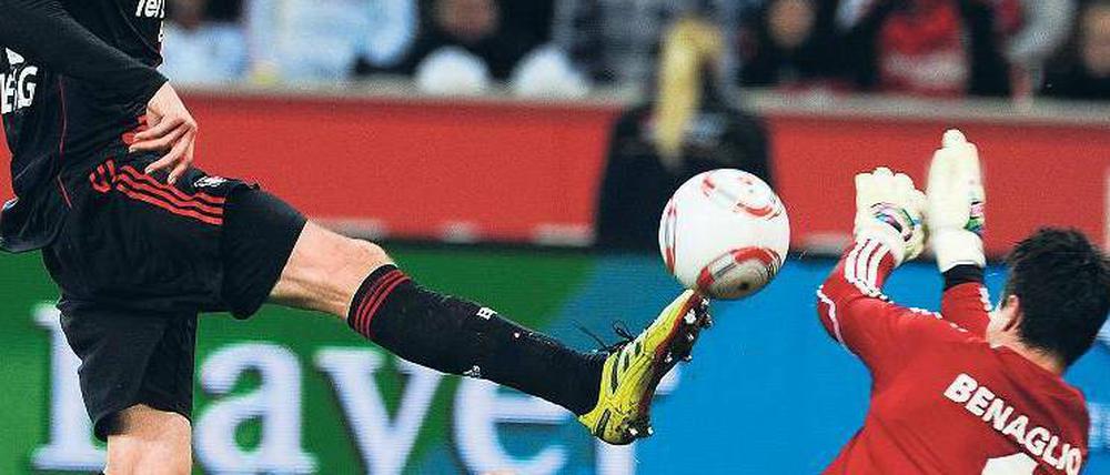 Einen Schritt schneller. Leverkusens Stefan Kießling lupft den Ball über Wolfsburgs Torhüter Diego Benaglio hinweg zum 3:0. Foto: AFP