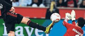 Einen Schritt schneller. Leverkusens Stefan Kießling lupft den Ball über Wolfsburgs Torhüter Diego Benaglio hinweg zum 3:0. Foto: AFP