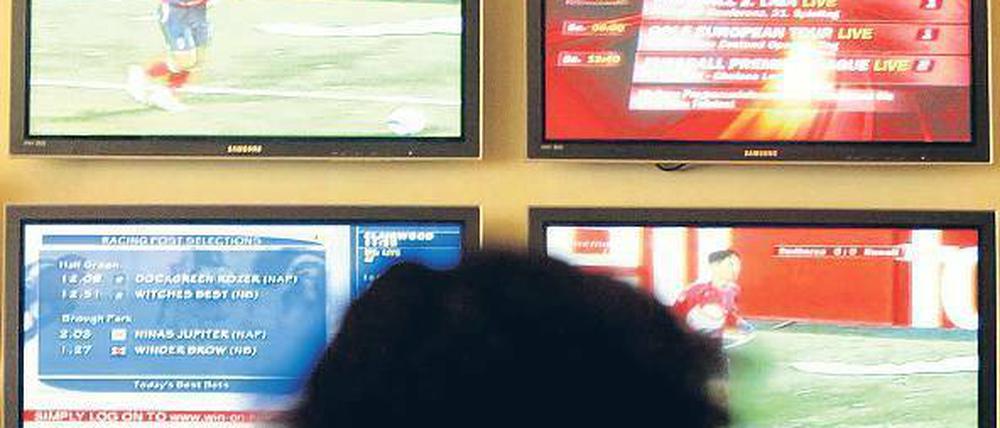 Schirm zum Glück? In Wettbüros informieren sich die Zocker über Quoten.