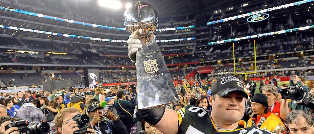 Stolz präsentieren die Green Bay Packers den Pokal.