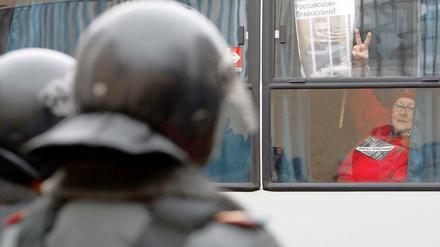 Eine Demonstrantin für den Ex-Oligarchen Michail Chodorkowski zeigt das Victory-Zeichen aus einem Polizei-Bus vor dem Gerichtsgebäude in Moskau.