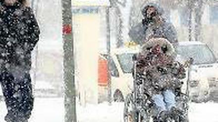 Bescheidene Wünsche. Die winterlich verschneite Stadt macht vielen das Leben schwer. Ältere Menschen bleiben derzeit aus Vorsicht lieber drinnen, und wer einen Behinderten im Rollstuhl zu bewegen hat, muss Schwerstarbeit leisten. Foto: Kumm/dpa
