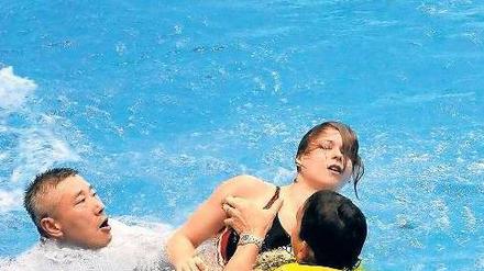 Trainer retten die bewusstlose Maria Kurjo in Rostock aus dem Wasser.