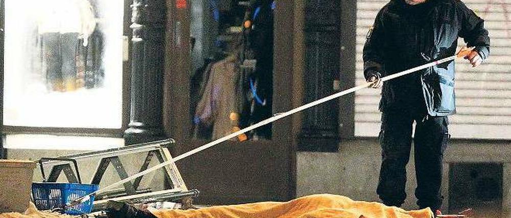 Tatort Stockholm. Ein Ermittler untersucht noch am Samstagabend einen der Anschlagsorte in der schwedischen Hauptstadt. Der Leichnam des getöteten Attentäters ist mit einer Plane abgedeckt. Am Sonntag waren hier wieder Passanten unterwegs. 