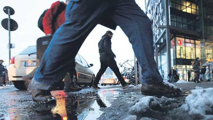 Matschig und rutschig. Wer am Hauptbahnhof zu den Bussen wollte, musste über dreckige Pfützen springen. Der Durchgangsverkehr der Taxis ließ dem Schnee hier keine Chance. Am Freitag soll es spätestens abends wieder schneien – die ganze Nacht hindurch. Sonnabend könnte es laut Wetterdienst dann regnen. Foto: Reuters/Thomas Peter
