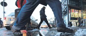 Matschig und rutschig. Wer am Hauptbahnhof zu den Bussen wollte, musste über dreckige Pfützen springen. Der Durchgangsverkehr der Taxis ließ dem Schnee hier keine Chance. Am Freitag soll es spätestens abends wieder schneien – die ganze Nacht hindurch. Sonnabend könnte es laut Wetterdienst dann regnen. Foto: Reuters/Thomas Peter