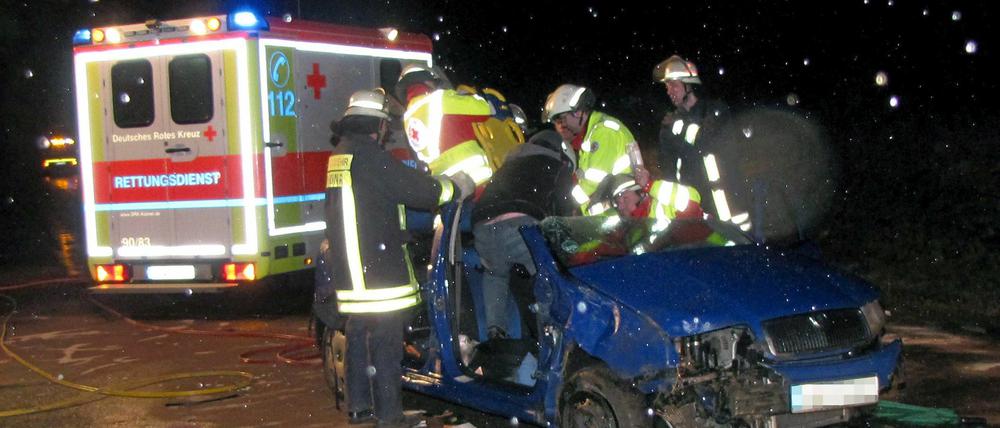 Rettungskräfte helfen einen verunglückten Autofahrer nach einer Unfallserie infolge von Eisglätte auf der A44 Dortmund - Kassel.