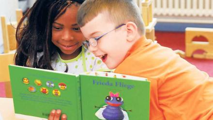 Hingucker. Diesen Erstklässlern in Berlin-Wedding hat eine Lesepatin bunte Bilderbücher mitgebracht. Doch die Leseförderung erreicht bei Weitem nicht alle Kinder, kritisieren Experten.