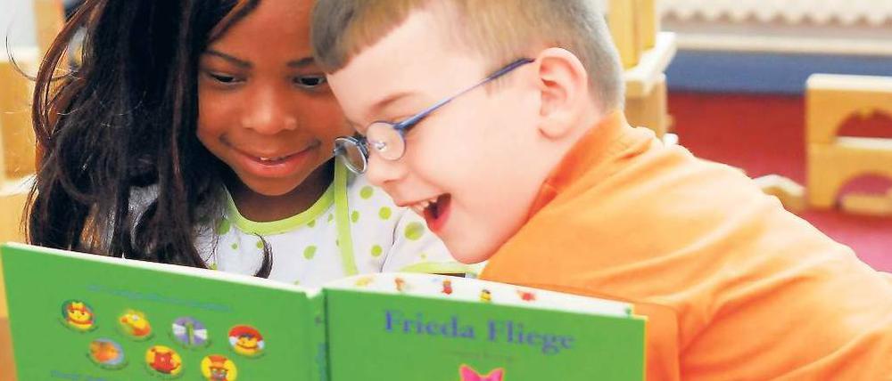 Hingucker. Diesen Erstklässlern in Berlin-Wedding hat eine Lesepatin bunte Bilderbücher mitgebracht. Doch die Leseförderung erreicht bei Weitem nicht alle Kinder, kritisieren Experten. 