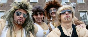 Narren bei der Weiberfastnacht in Düsseldorf spielen Dinosaurier des Testosteron-Zeitalters.