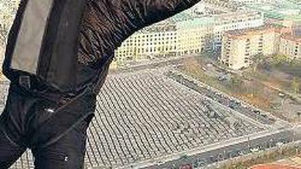 Absprung in der Innenstadt. Mit einem Fallschirm springt dieser Extremsportler am Potsdamer Platz in die Tiefe – diese Aktion war allerdings genehmigt. 