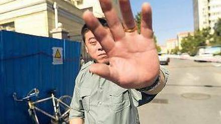 Keine Fotos. Am Haus, in dem die Frau des chinesischen Nobelpreisträgers wohnt, sind Aufnahmen unerwünscht. Ein Sicherheitsmann behindert den Fotografen. Foto: Peter Parks/AFP