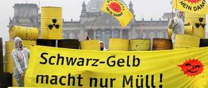 "Schwarz-Gelb macht nur Müll" steht auf einem Transparent, daneben wehen "Atomkraft?-Nein Danke"-Fahnen bei einer Aktion von Anti-AKW-Aktivisten imRegierungsviertel in Berlin bei einer Demonstration gegen die Kernenergie vor dem Reichstag. 