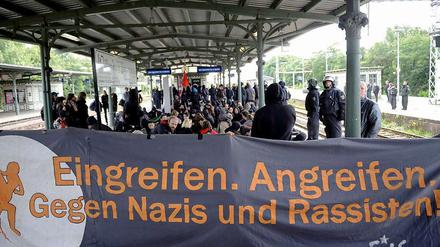 Gegendemonstranten versammeln sich auf dem Bahnhof.