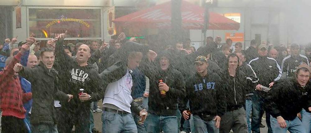 Und dann stehst du im Regen: Trotz Wasserwerfer der Polizei wollen diese HSV-Fans noch nicht nach Hause gehen.