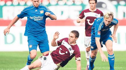Abgegrätscht: Hannovers Abdellaoue fährt Michael Ballack (l.) in die Beine, der später verletzt vom Feld muss. Sami Hyypiä (r.) verliert nur vom Zusehen schon das Gleichgewicht.