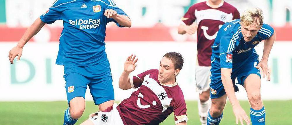 Abgegrätscht: Hannovers Abdellaoue fährt Michael Ballack (l.) in die Beine, der später verletzt vom Feld muss. Sami Hyypiä (r.) verliert nur vom Zusehen schon das Gleichgewicht.