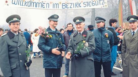 Sag es mit Blumen. Hallöchen am Ostpreußendamm: Ordnungshüter aus Lichterfelde und Teltow schütteln sich am 14. November 1989 die Hände. Foto: Zenit/laif