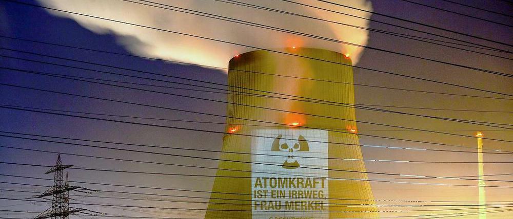 Greenpeace Aktivisten projizieren in Lingen den Schriftzug "Atomkraft ist ein Irrweg, Frau Merkel" auf den Kühlturm des Atomkraftwerkes Emsland.
