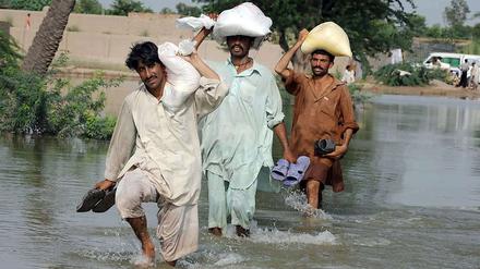 Flüchtende waten durch das Hochwasser hin zu höhergelegenen Orten und Städten.