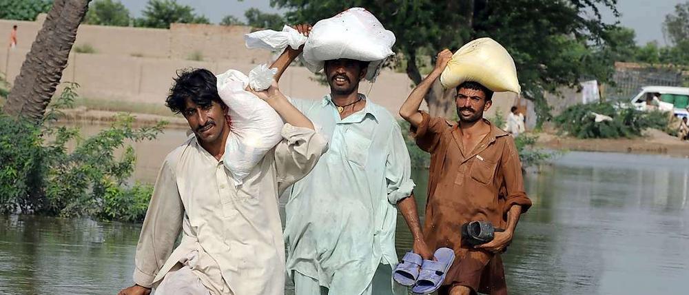 Flüchtende waten durch das Hochwasser hin zu höhergelegenen Orten und Städten.