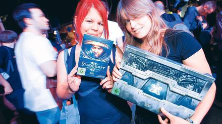 Spaß? Von wegen! Das ist seriöses Lehrmaterial. Sagen zumindest Laura Li Tung (links) und Kira Jung. Die beiden Frauen sind in der Nacht extra zum Alex gefahren, um das neue Spiel zu kaufen. Warum? Sie sind Studentinnen der Games Academy, die sich in der Nähe befindet: am S-Bahnhof Jannowitzbrücke. Foto: Davids/Zinken