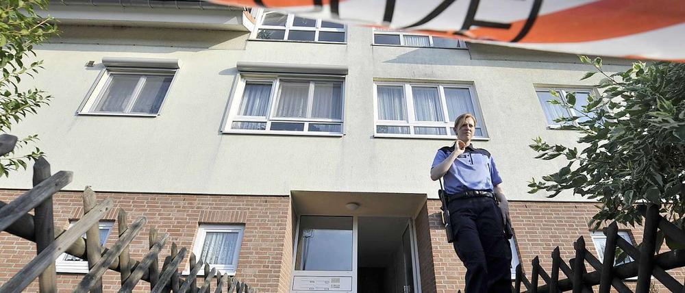 Eine Polizistin steht am Mittwoch in Velten vor einem Wohnhaus, in dem in einer Wohnung zwei Leichen entdeckt worden sind.