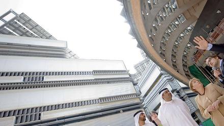 Angela Merkel lässt sich in Abu Dhabi das Modell der Ökostadt Masdar City erklären.