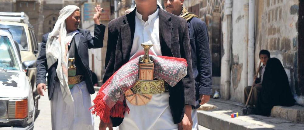 Mit Krummdolch und Gebetsteppich: Dieser junge Mann in der Hauptstadt Sanaa repräsentiert den sittenstrengen, tribalen Norden. Im ehemaligen sozialistischen Süden war das Bildungsniveau höher und die Gleichberechtigung weit verbreitet.