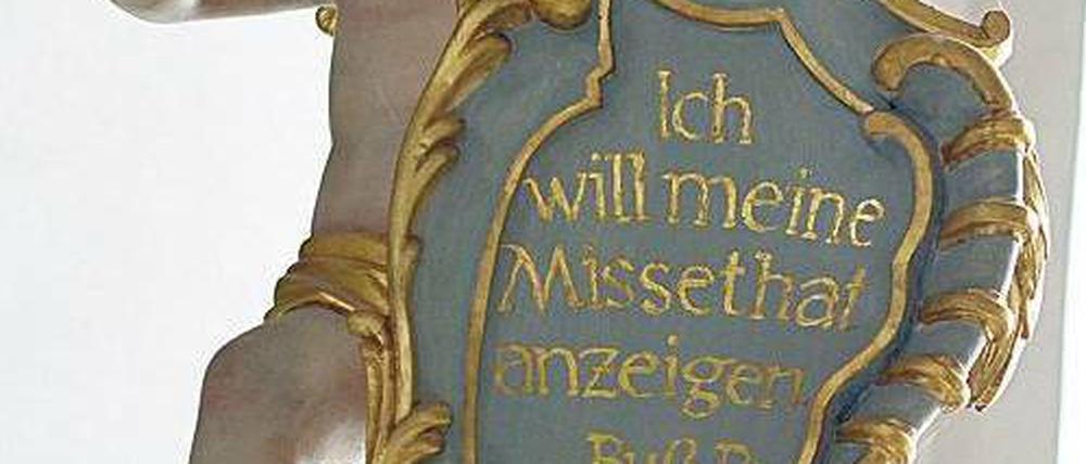 Die Reue der Kirche. Diese Engelsfigur über einem Beichtstuhl in der Basilika Vierzehnheiligen in Bad Staffelstein in Oberfranken hält eine Tafel mit einem Buß-Psalm. x