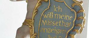 Die Reue der Kirche. Diese Engelsfigur über einem Beichtstuhl in der Basilika Vierzehnheiligen in Bad Staffelstein in Oberfranken hält eine Tafel mit einem Buß-Psalm. x