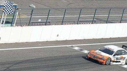 Die erste Zielflagge. Mercedes-Fahrer Gary Paffett siegt im ersten DTM-Rennen. Foto: dpa