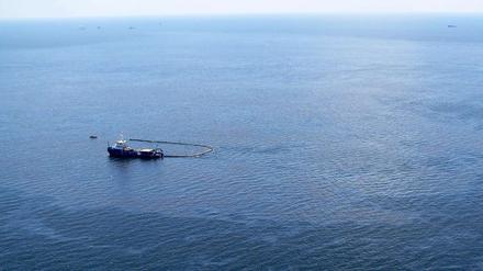 Ein Boot versucht das ausgelaufene Öl der gesunkenen Bohrinsel „Deepwater Horizon“ aufzufangen. Jetzt soll ein Unterwasser-Roboter das ausströmende Öl stoppen.