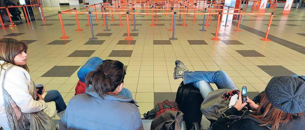 Bankdrücker in Schönefeld. Vorteil: Warteschlangen gibt es nicht. Nachteil: Man kommt trotzdem nicht voran. Junge Touristen teilen per SMS mit, dass sie später kommen.